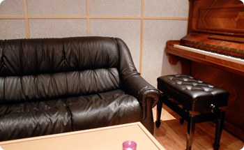 Le coin salon du studio, canapé et piano droit